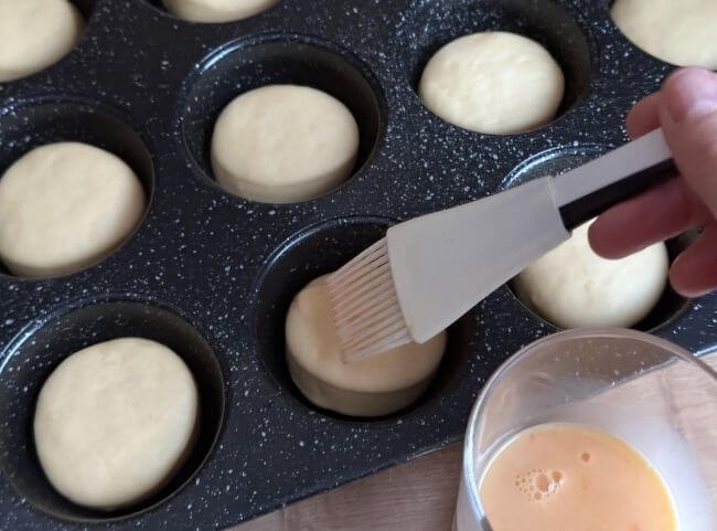 Mini-Burger Buns mit Ei bestreichen Mini-Burger Buns mit Ei bestreichen